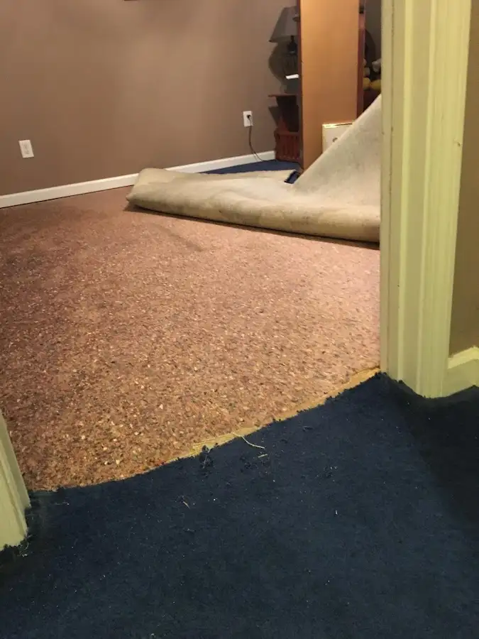Carpet pad removal revealing water damage during Water Mitigation Services in Matthews